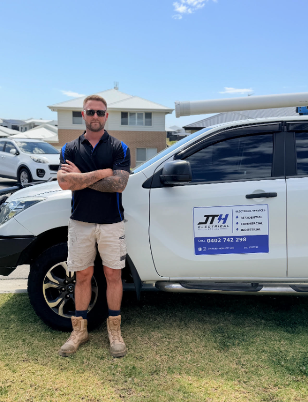Justin, owner and licensed electrician at JTH Electrical, beside the company vehicle